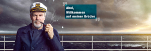 Ein alter Kapitän steht mit einer Pfeife bei rauher See an Deck und begrüßt den Besucher von Schiffsradar24.de