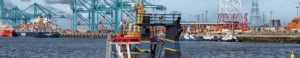 Ein Schlepper vor der Kulisse eines Containerhafens - Hamburger Hafen